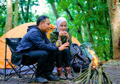 Couple Camping in Forest with Campfire